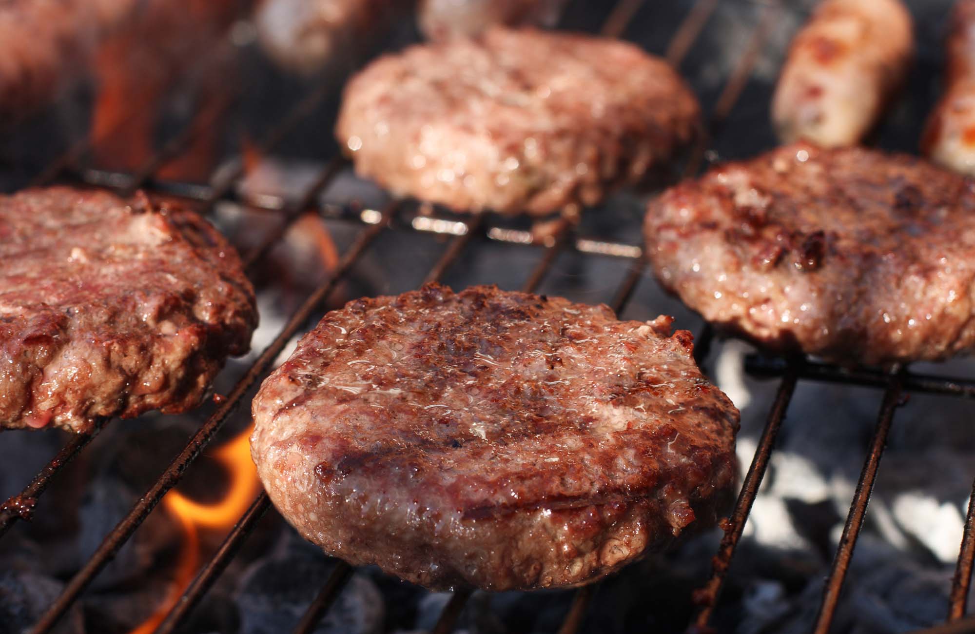 Food meat - burgers on barbecue grill. Shallow dof.